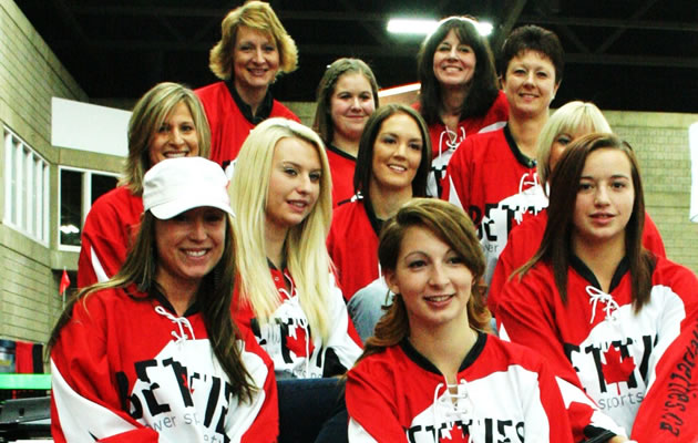A group shot of women and girls wearing bright red jerseys. 
