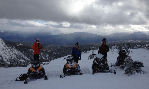 4 snowmobilers on a ridge in the Babcock riding area. 