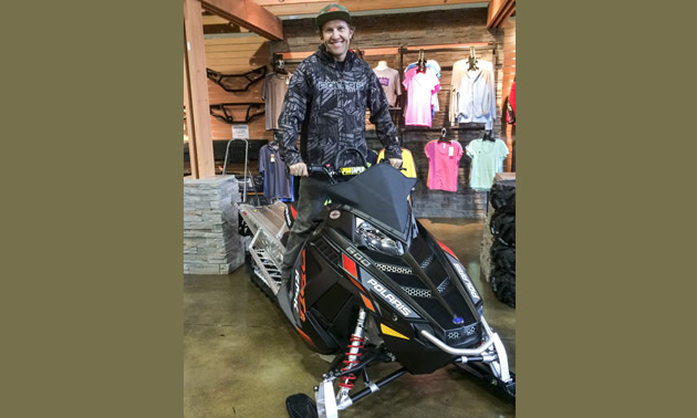 Chris Brown sitting on a Polaris snowmobile