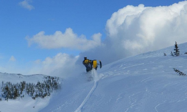 A snowmobiler cresting a hill near Mackenzie.
