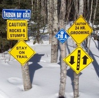 Numerous signs posted on a trail.