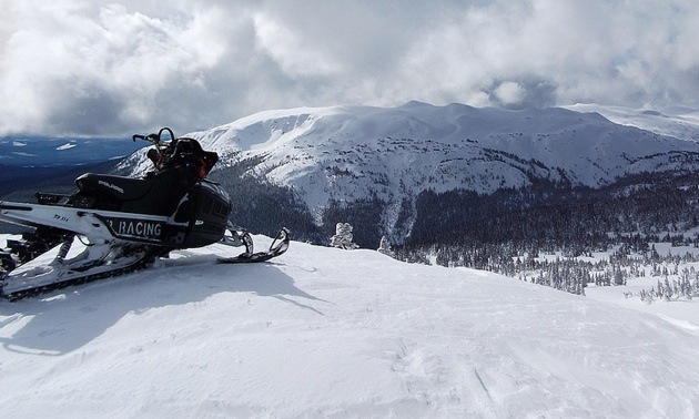 A snowmobile overlooking the Telkwa Range. 