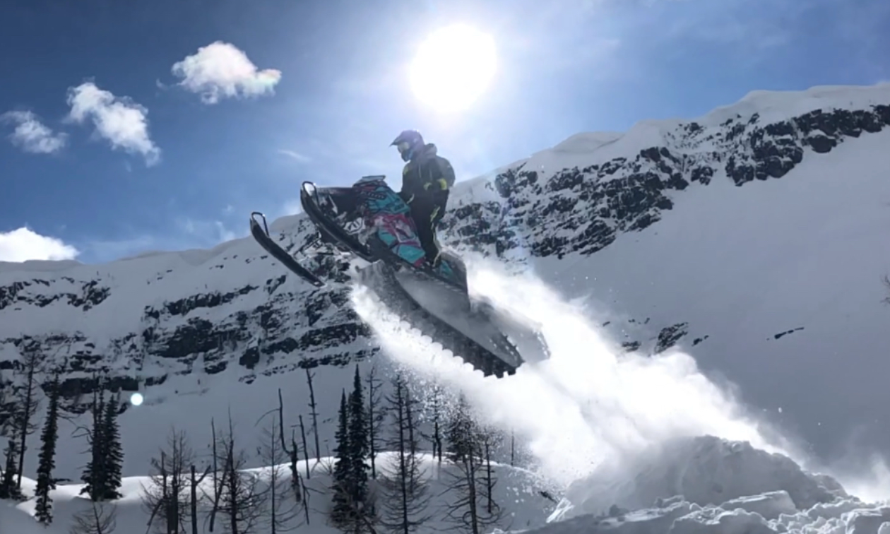 Sheldon Kelly gets a big jump on his snowmobile on a sunny day.