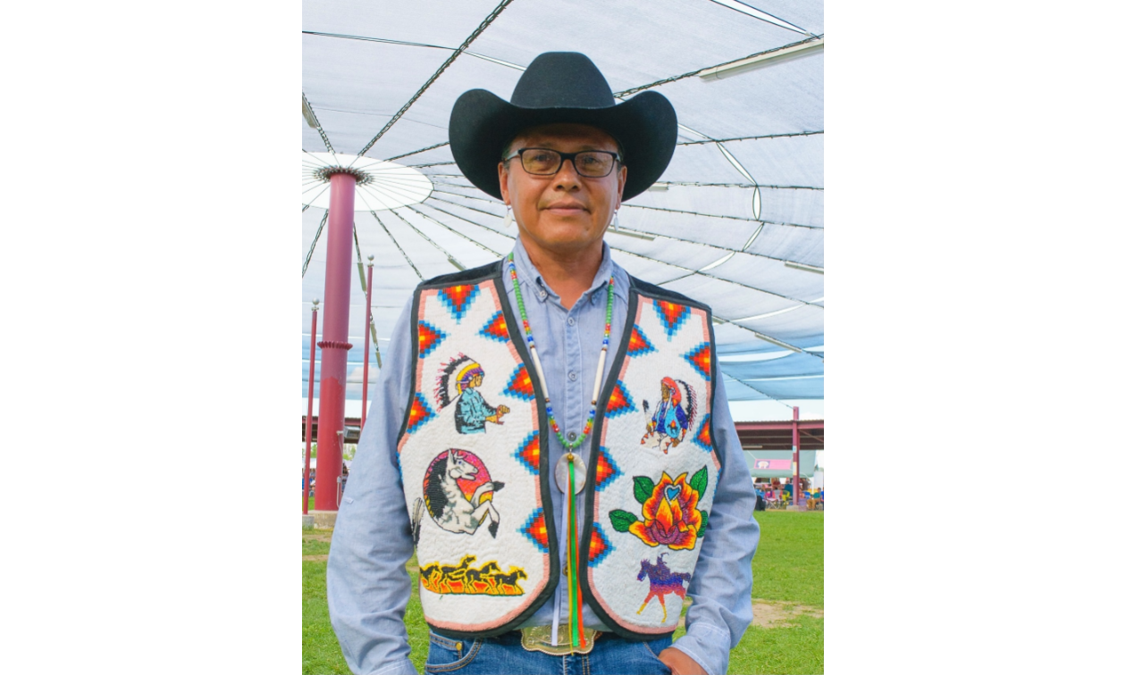 Alonzo Coby wears a cowboy hat and a colourful vest. 