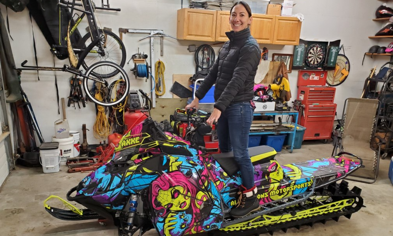 Alysha Vlahovich stands up on her 2022 Polaris RMK Khaos Matryx Slash 155 3” with custom sled wrap. 