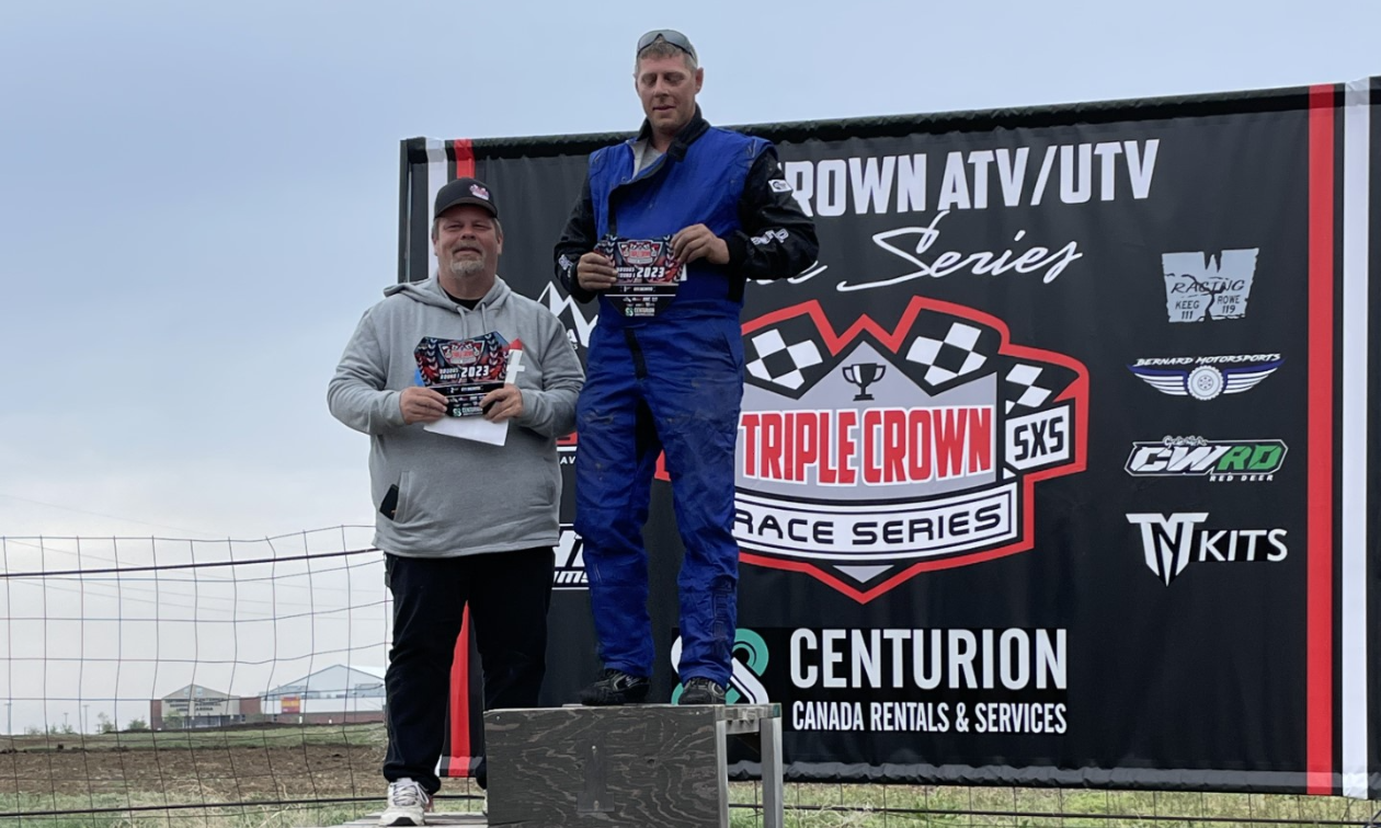 Richard Bernard stands on top of a podium at the Triple Crown Race Series. 