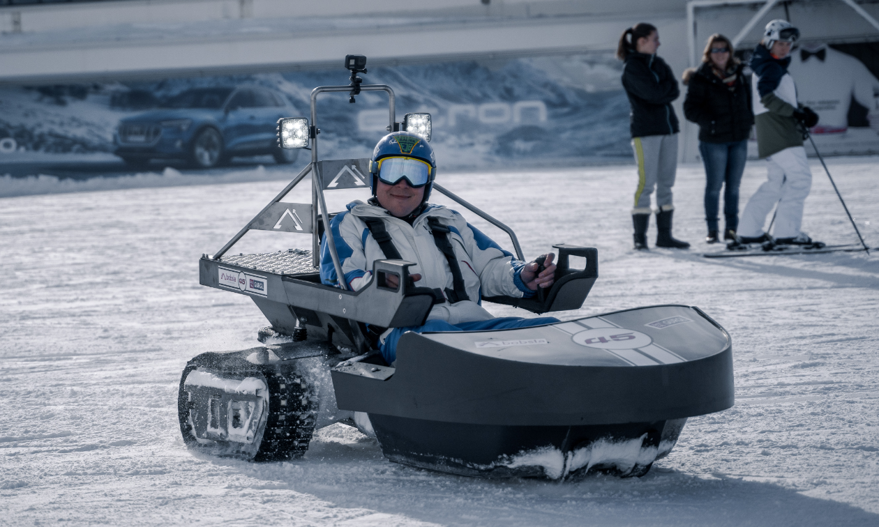 A man rides inside a Bobsla electric snowmobile.