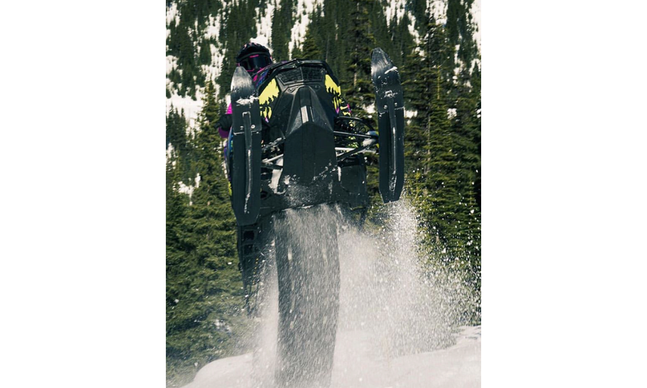 Chantelle Bourgeau does a wheelie on a black snowmobile. 