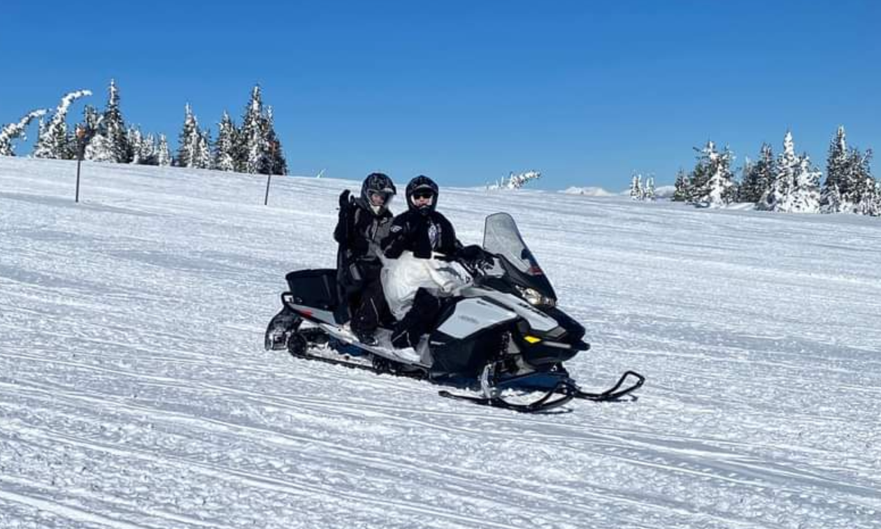 Chris drove her sled with a friend on the back to the peak of Two Top in a formal wedding dress. 