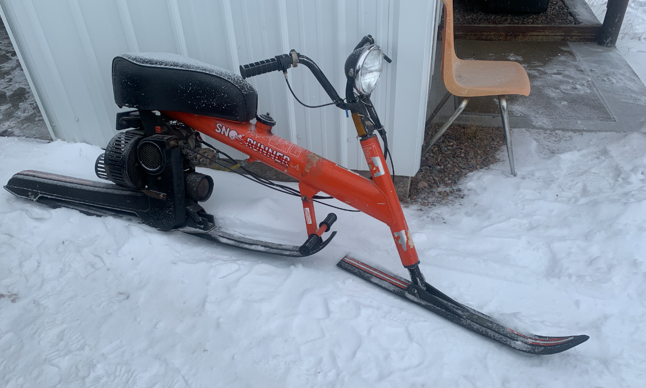 An old red snow scooter machine. 