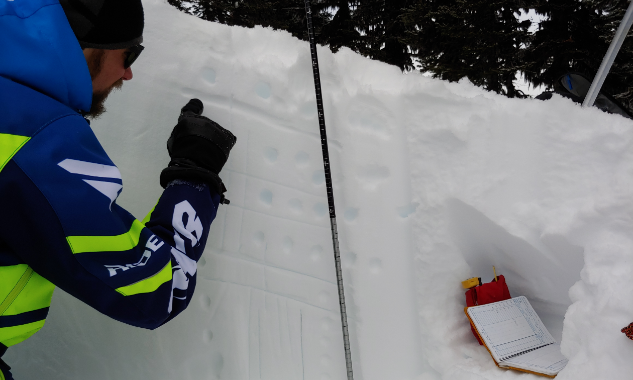 Grant Helgeson checks a snowpack for information he can gather potential avalanche data. 