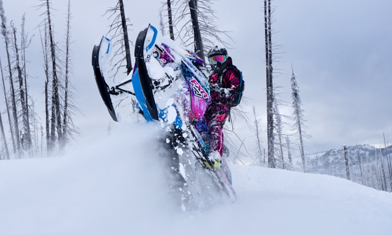 Kelsey Fay does a wheelie with her pink and blue snowmobile. 