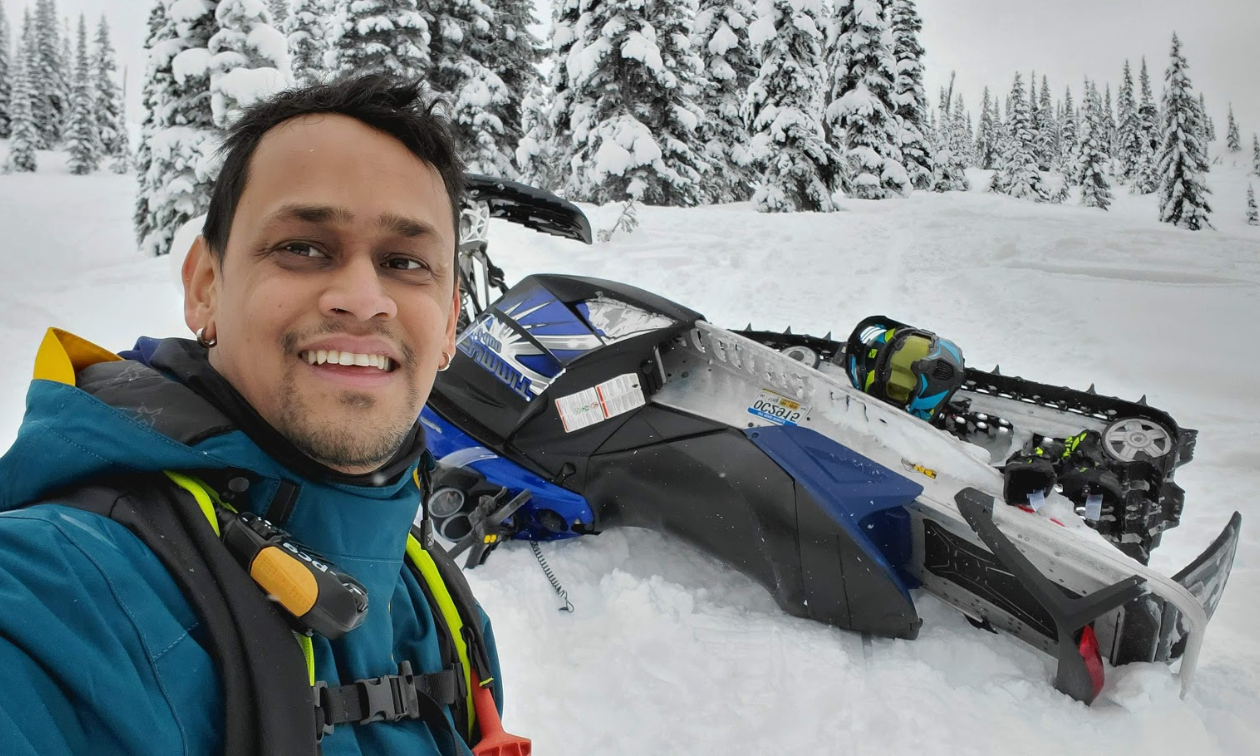 Melvin Garib smiles while his 2018 Polaris RZR S4 900 is parked on its side behind him. 