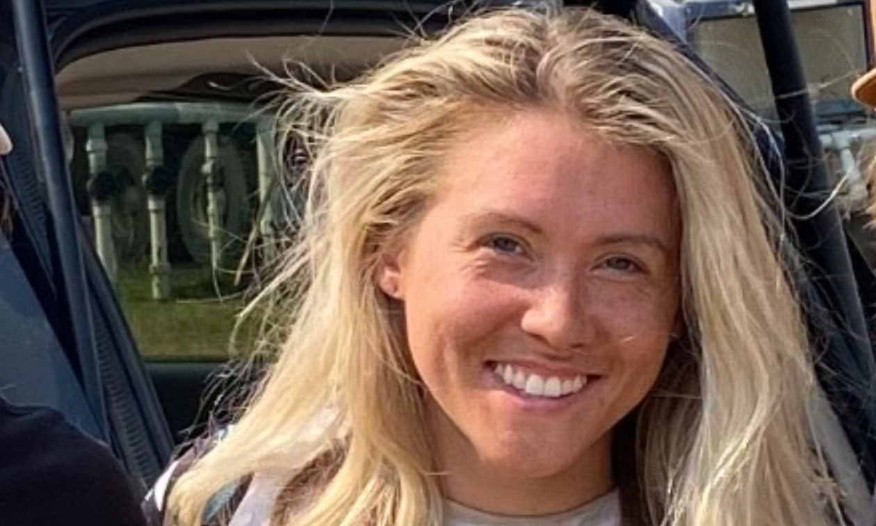 Sammi Lynn Clayton smiles for a photo in front of an ATV. 