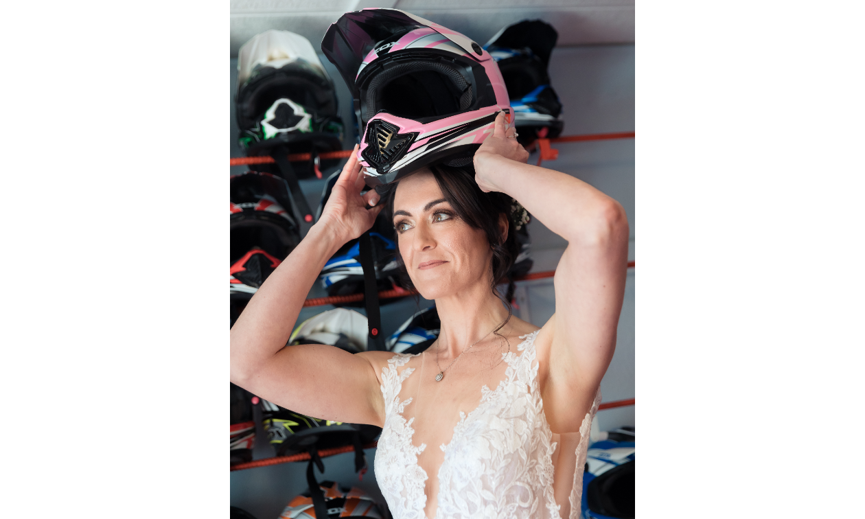 Sarah Liebeknecht puts a snowmobile helmet over her head while wearing a wedding dress. 