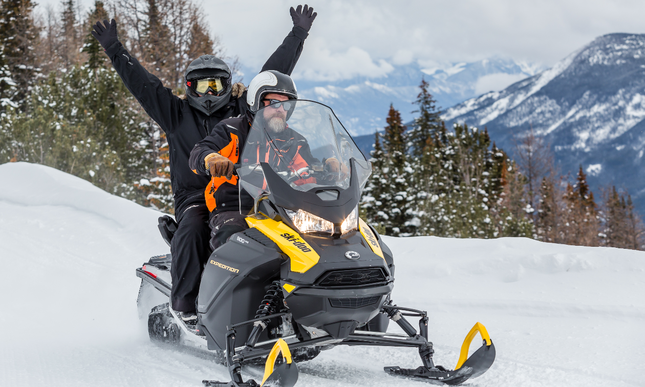 Sarah Liebeknecht throws up her hands in celebration while getting a ride on a snowmobile in B.C.’s Purcell Mountains. 