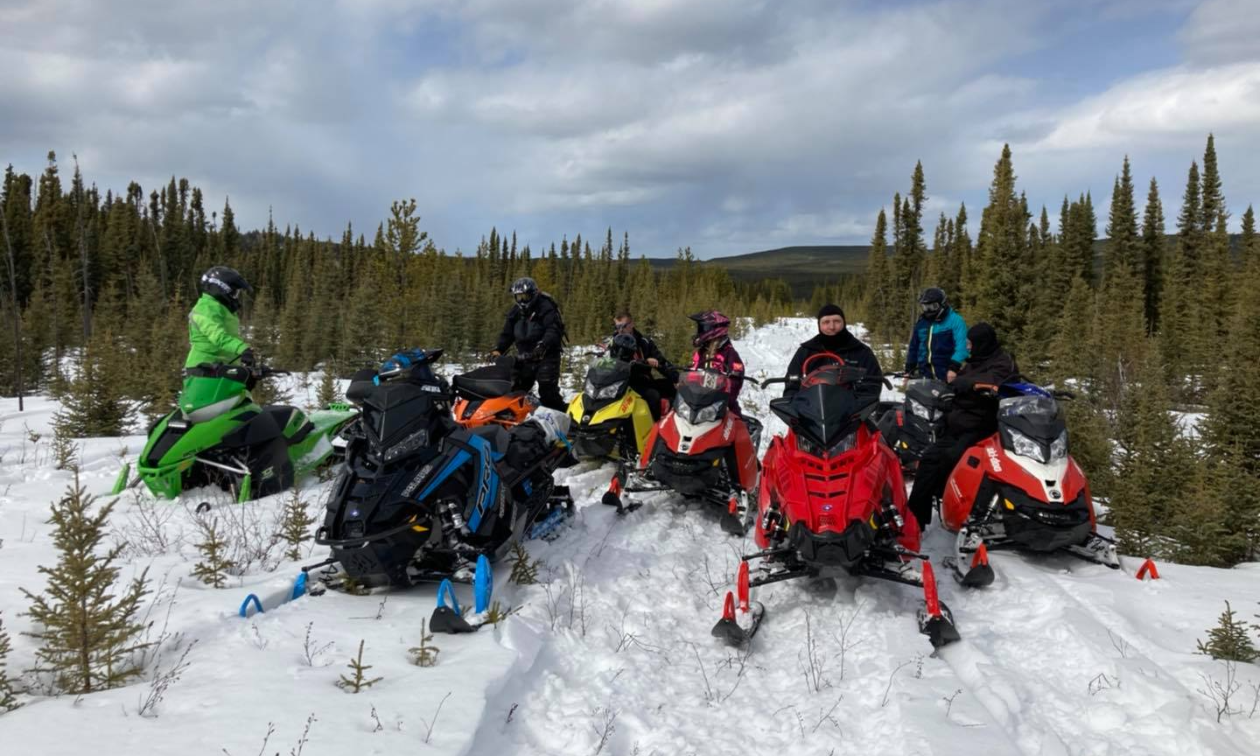 A line of snowmobilers on a trail in Swan Hills, Alberta.
