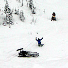 A man waves from the bottom of a snowy hill in around Valemount, BC.