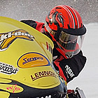 Pro snowmobile racer in a yellow snowmobile during a race in Manitoba