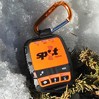 Orange and black Spot GPS device in the snow. 