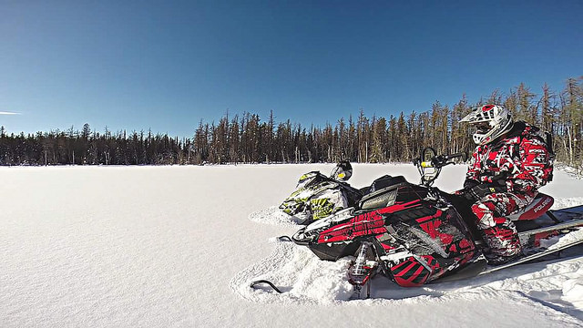 Curt Dauvin sitting on his sled looking out at the endless fresh powder on the meadowns in northern Saskatchewan.