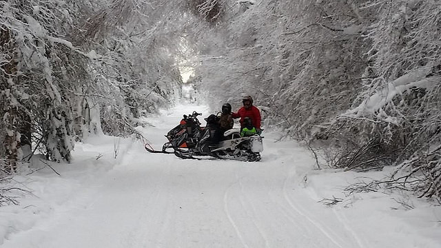 Two sledders stopped on a snow-covered trail near Whitecourt, Alberta.