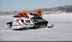 Two sleds compete in a vintage oval race. 