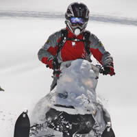 A rider in a red jacket on a Ski-Doo. 