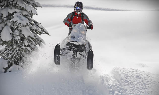 A rider in a red jacket on a Ski-Doo. 