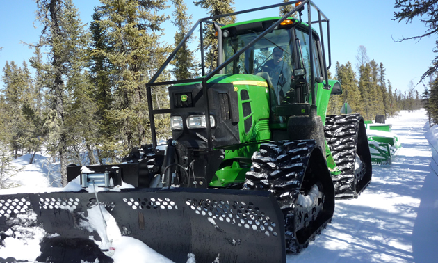 A John Deere tractor with a track kit for grooming snowmobile trails. 