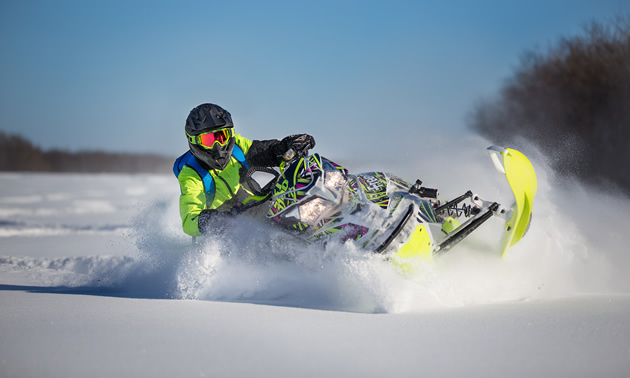 A snowmobiler carving through fresh powder in Saskatchewan. 