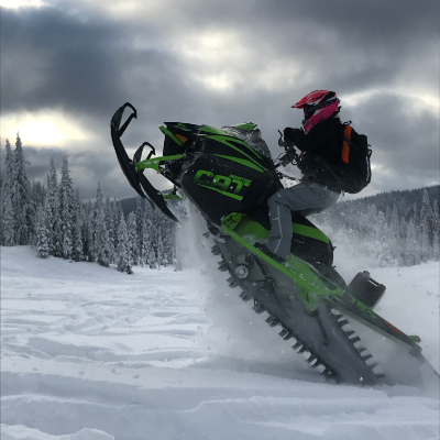 Meghan Bosecker pulls a wheelie on her green and black 2018 Arctic Cat M8000 Mountain Cat 153”.