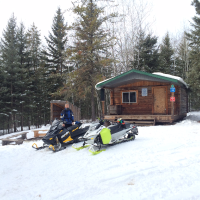 Chris Rourke poses on his snowmobile in front of a warm-up shelter