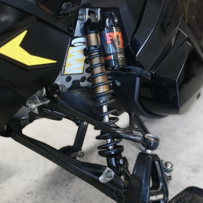 A close look at snowmobile suspension on a black snowmobile.