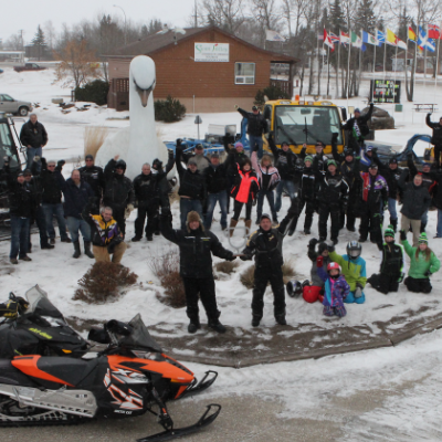 The Swan Valley Snowmobile Club is gathered to celebrate their Sledtown Showdown contest win in 2015.