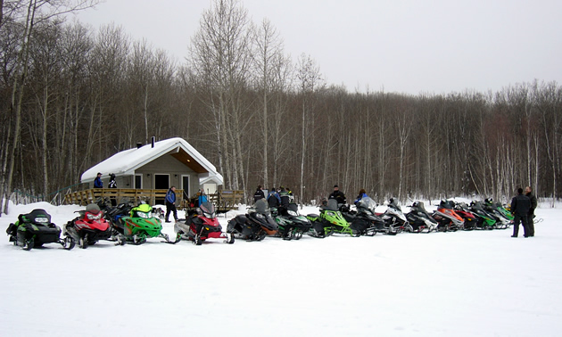 A group of sledders lined up in front of a shelter. 