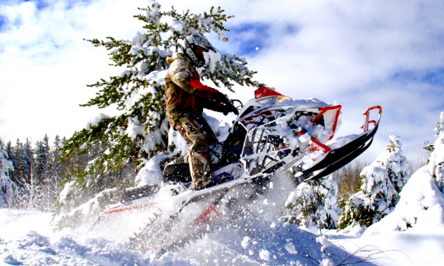 A snowmobiler plows through a snowy jump in Flin Flon, Manitoba. 