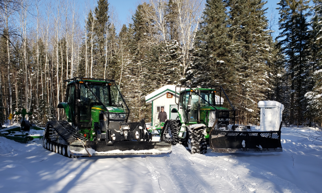 Two tractors in front of a warm-up shelter.