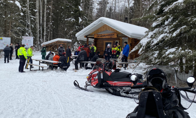 Snowmobilers gather around a cabin in the snow in Whitecourt, Alberta. 