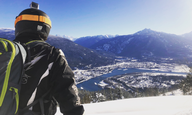 A snowmobiler looks down upon Revelstoke from a high location on Boulder Mountain.