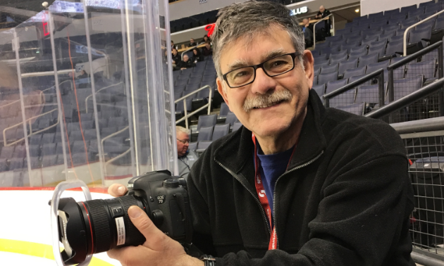 Darryl Gershman smiles while posing with his camera at the MTS Centre in Winnipeg, Manitoba.