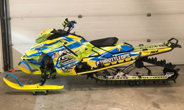 A bright neon green and dark blue snowmobile.