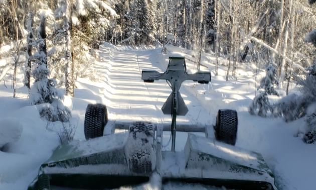 A drag smooths snow along a snowmobile trail.