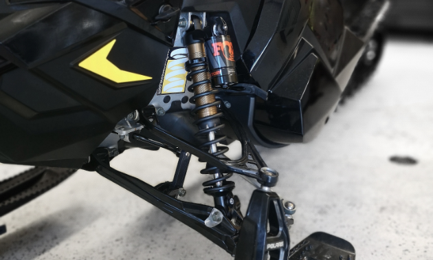 A close look at snowmobile suspension on a black snowmobile.