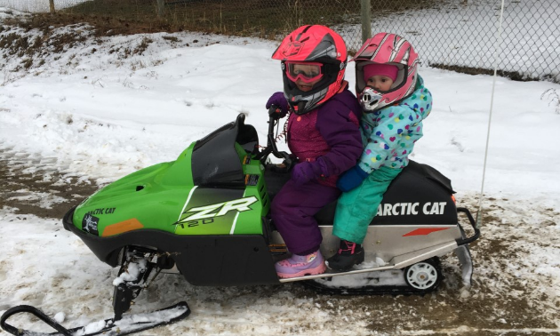 “Let’s go, Dad!” Paisley and Brooklyn are ready for another snowmobiling adventure.