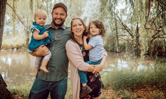 Drew and Liane Leger smile with their two daughters, Claire (three years old) and Marissa (one year old).