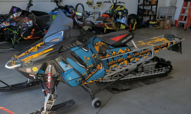 A blue and orange custom sled wrap on a snowmobile.