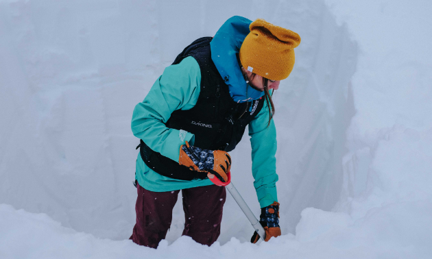 Brittney Dickson demonstrates how to evaluate snowpack safety by digging a snow pit. 