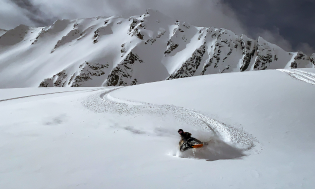 A snowmobiler shreds through fresh snow.