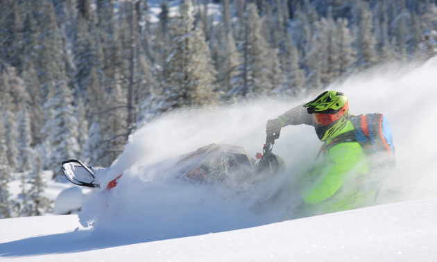 A green sledder carves through pristine snow. 